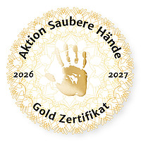 Rundes Siegel mit der Aufschrift „Aktion Saubere Hände“, zwei Handabdrücken in der Mitte und dem Text „Gold Zertifikat 2026–2027