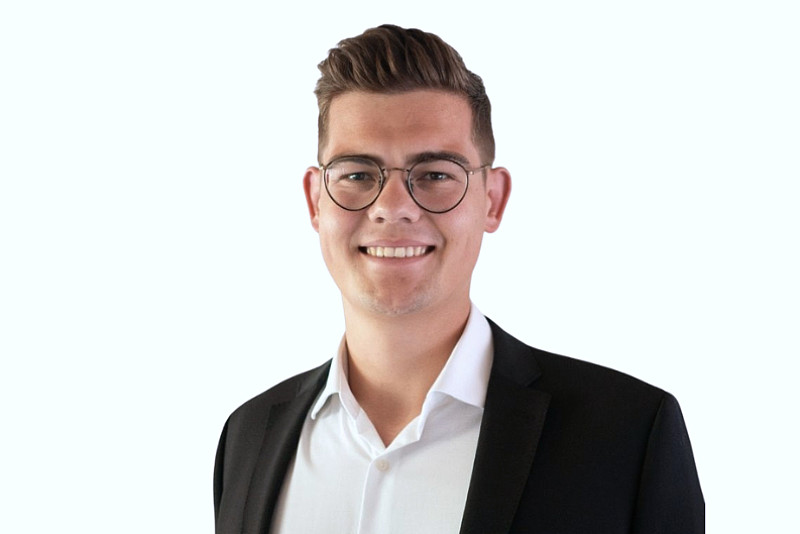 Portrait eines Mannes im weißen Hemd und dunklem Anzug vor neutralem Hintergrund