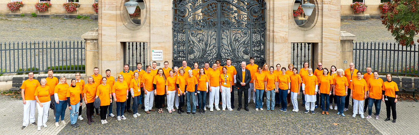 Gruppenbild vor dem Pariser Tor, die Menschen tragen orangene Shirts