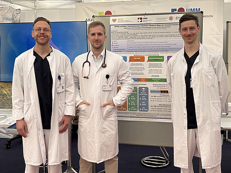 Drei Ärzte der Kardiologie in weißen Kitteln am Maimarkt-Stand der UMM.