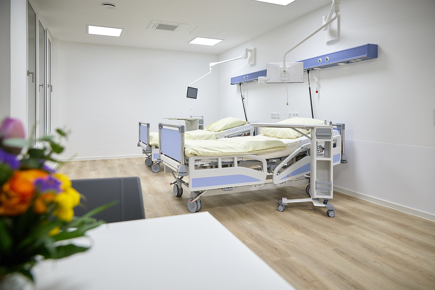 2 Betten auf Station, Blumen schmücken den Raum