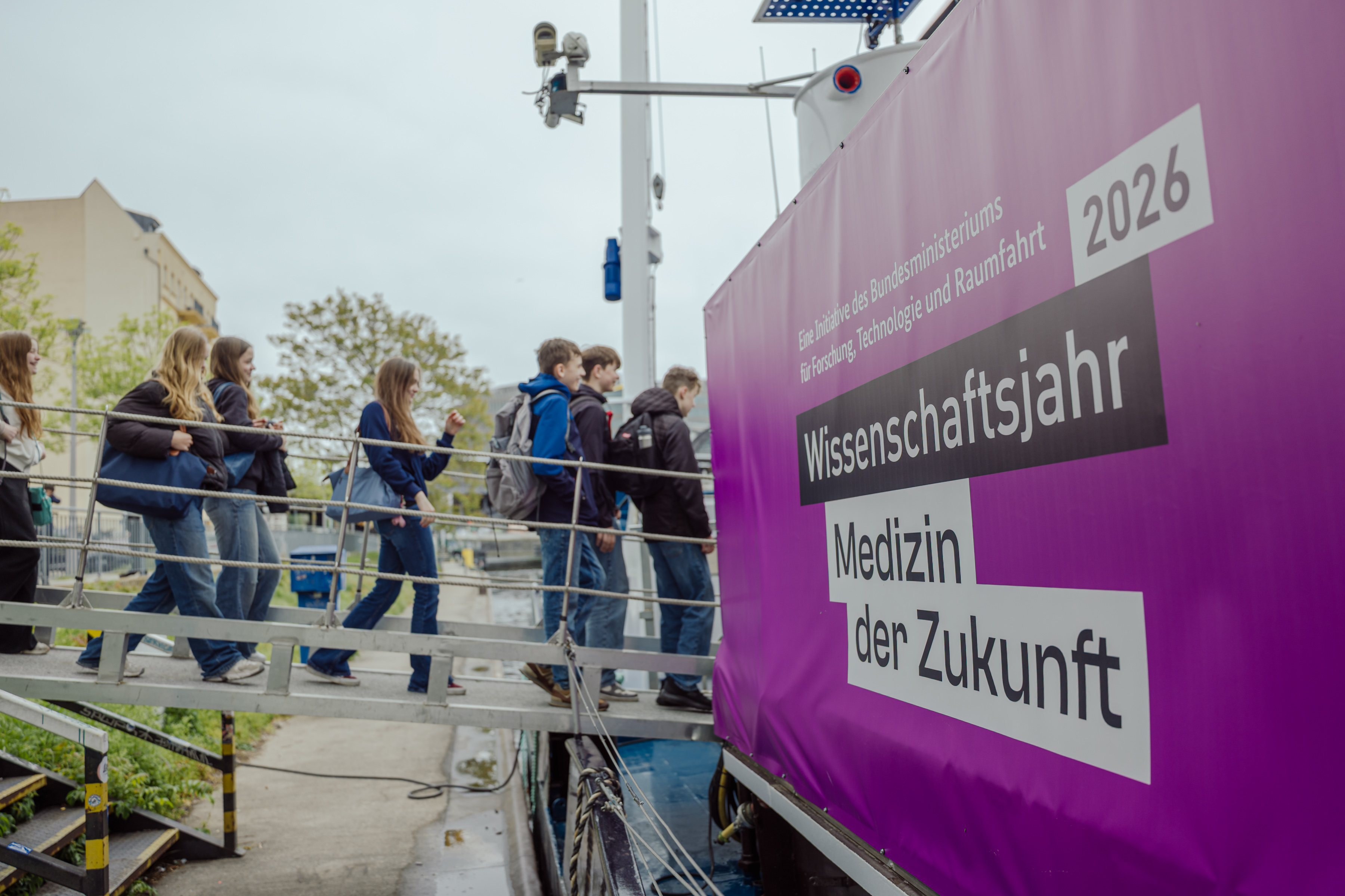 Das Foto zeigt Menschen, die über einen Steg das Ausstellungsboot MS Wissenschaft betreten